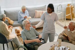 A small group of older adults socializing around a table with healthy snacks and drinks.